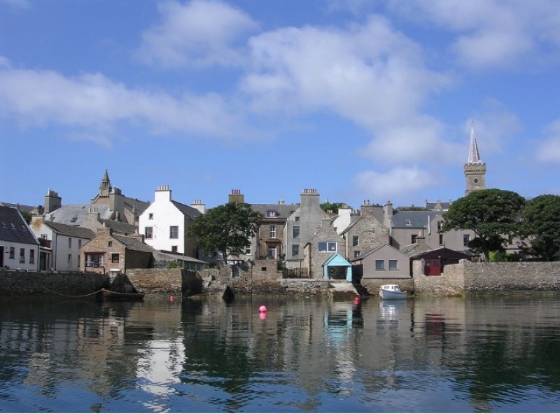 Stromness from the sea showing the houses huddled together along the harbour. Image credit: Creative commons